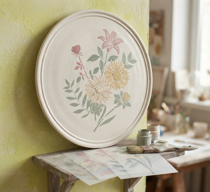 Botanical decoupage stencil set with five floral and leaf patterns beside a decorated wooden box